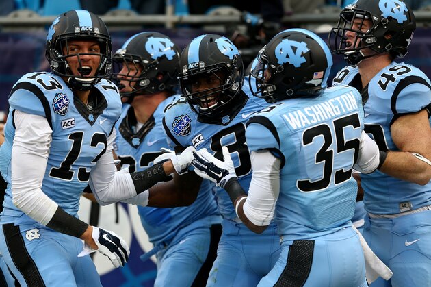 CHARLOTTE, NC - DECEMBER 28:  T.J. Logan #8 of the North Carolina Tar Heels celebrates with teammates after returning a kick for a touchdown during their game against the Cincinnati Bearcats at Bank of America Stadium on December 28, 2013 in Charlotte, North Carolina.  (Photo by Streeter Lecka/Getty Images)
