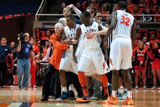 Jan 4, 2014; Champaign, IL, USA;  Illinois Fighting Illini head coach John Groce holds back his team during a skirmish during the second half against the Penn State Nittany Lions at State Farm Center.  Illinois defeated Penn State 75-55.  Mandatory Credit: Bradley Leeb-USA TODAY Sports