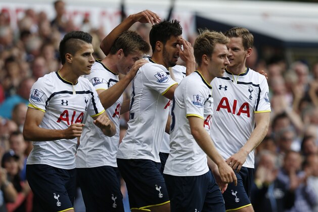 Tottenham Hotspur's Nacer Chadli, center, celebrates his goal against Queens Park Rangers with teammates during their English Premier League soccer match at White Hart Lane, London, Sunday, Aug. 24, 2014. (AP Photo/Sang Tan)