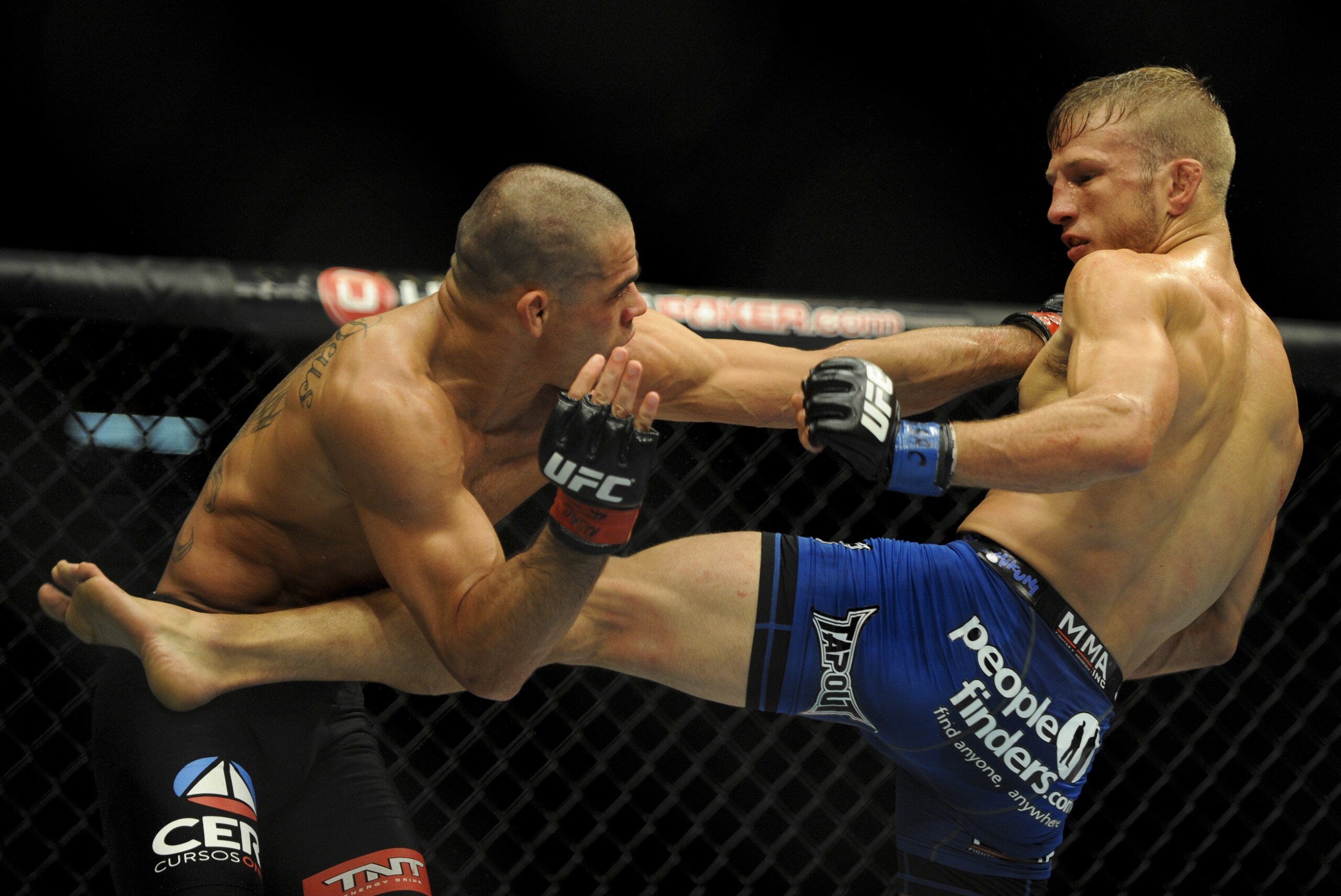 May 24, 2014; Las Vegas, NV, USA;   TJ Dillashaw (blue) lands a kick on Renan Barao (red) during their UFC 173 bantamweight championship bout at MGM Grand Garden Arena. Dillashaw won the bout by way of TKO. Mandatory Credit: Stephen R. Sylvanie-USA TODAY Sports
