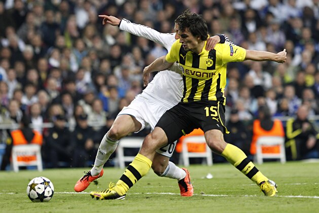 Madrid's Gonzalo Higuain from Argentina, left, and Dortmund's Mats Hummels vie for the ball during the Champions League semifinal second leg soccer match between Real Madrid and Borussia Dortmund at the Santiago Bernabeu stadium in Madrid, Spain, Tuesday April 30, 2013. (AP Photo/Alberto Di Lolli)