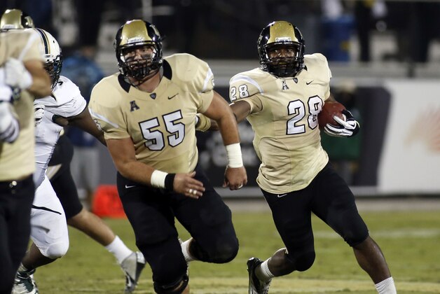 Central Florida running back William Stanback (28) follows the block of  Joey Grant (55) during the first half of an NCAA college football game on Friday, Nov. 29, 2013, in Orlando, Fla. UCF won 23-20. (AP Photo/Reinhold Matay)