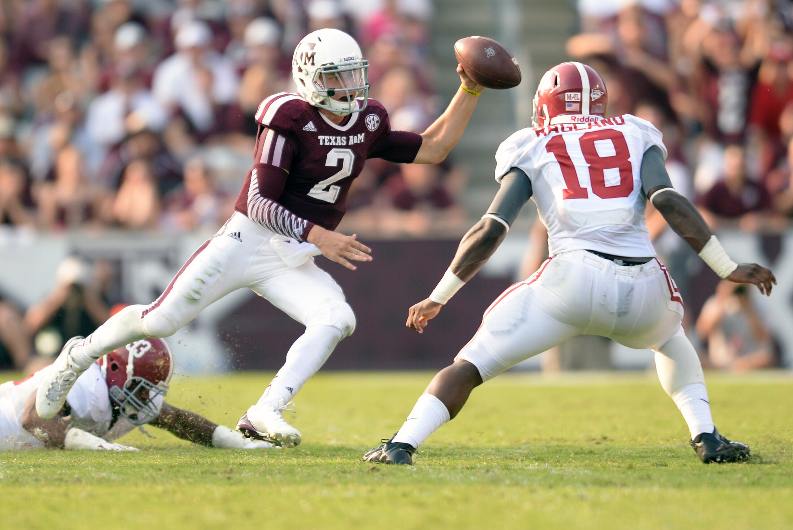 Sep 14, 2013; College Station, TX, USA; Texas A&M Aggies quarterback Johnny Manziel (2) scrambles from Alabama Crimson Tide linebacker Reggie Ragland (18) and linebacker Trey DePriest (33) during the second half at Kyle Field. Mandatory Credit: Thomas Campbell-USA TODAY Sports