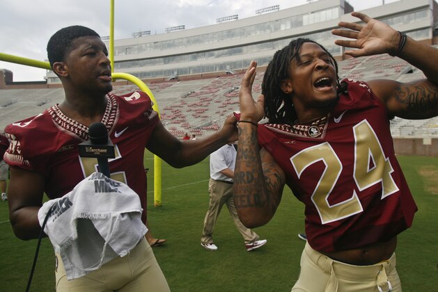 Playing reporter, Florida State quarterback Jameis Winston (5) collars teammate linebacker Terrance Smith (24) for an interview during their NCAA college football media day on Sunday, Aug. 10, 2014, in Tallahassee, Fla. (AP Photo/Phil Sears)
