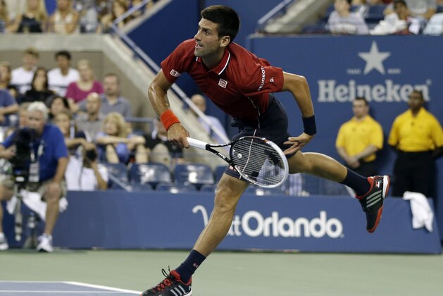 Novak Djokovic, of Serbia, follows through on a serve to Diego Schwartzman, of Argentina, during the opening round of the U.S. Open tennis tournament Monday, Aug. 25, 2014, in New York. (AP Photo/Darron Cummings)