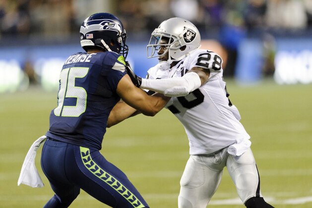 Aug 29, 2013; Seattle, WA, USA; Seattle Seahawks wide receiver Jermaine Kearse (15) blocks Oakland Raiders cornerback Phillip Adams (28) during the game at CenturyLink Field. Seattle defeated Oakland 22-6. Mandatory Credit: Steven Bisig-USA TODAY Sports