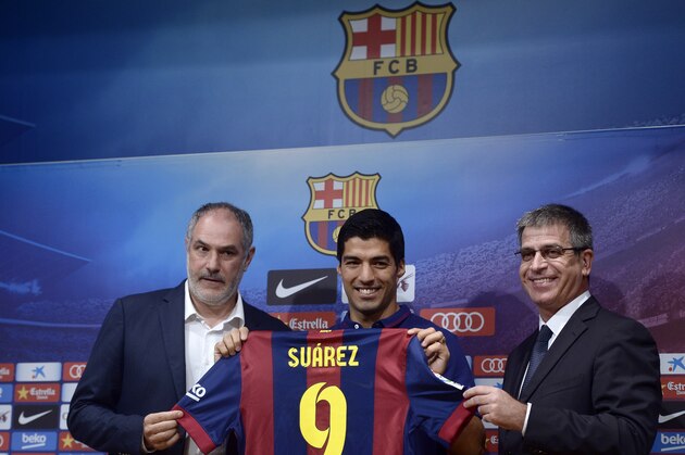 FC Barcelona's Luis Suarez, from Uruguay, center, poses with Barcelona's sports director Andoni Zubizarreta, left, and Barcelona's vice-president Jordi Mestre during a press conference of his presentation at the Camp Nou in Barcelona, Spain, Tuesday, Aug. 19, 2014. Barcelona unveiled Suarez on Tuesday, an event delayed for over five weeks since his transfer from Liverpool due to his latest suspension for biting an opponent at the World Cup. (AP Photo/Manu Fernandez)
