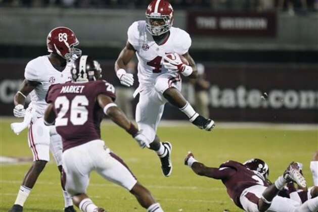 FILE -- In a Nov. 16, 2013, file photo Alabama running back T.J. Yeldon (4) leaps past an attempted tackle by Mississippi State defensive back Will Redmond, right, as defensive back Kendrick Market (26) closes in during the first quarter of an NCAA college football game in Starkville, Miss.   Yeldon will likely become the face of the Crimson Tide and is expected to be a candidate for next season’s Heisman Trophy. (AP Photo/Rogelio V. Solis, file)