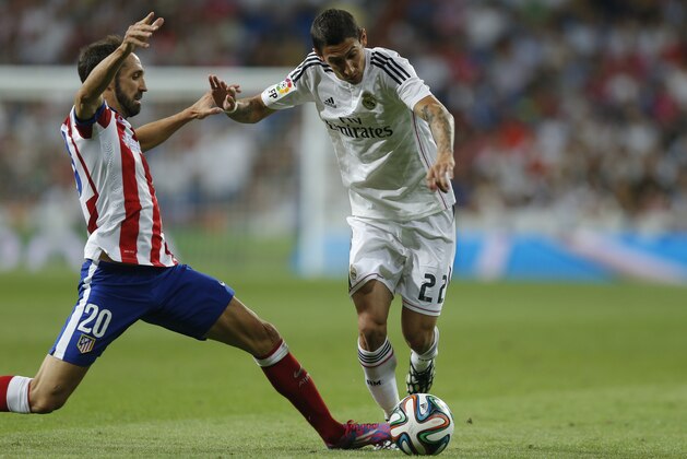 Real Madrid's Angel Di Maria, right, duels for the ball with Atletico Madrid's Juan Fran during a Spanish Super Cup soccer match at Santiago Bernabeu stadium  in Madrid, Spain, Tuesday, Aug. 19, 2014 . (AP Photo/Daniel Ochoa de Olza)