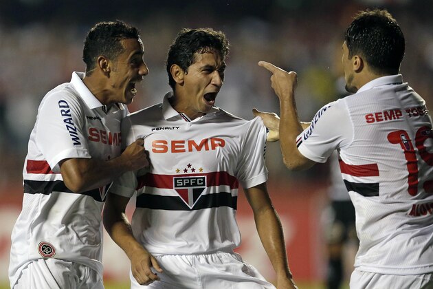 Paulo Henrique Ganso of Brazil's Sao Paulo FC, center, celebrates with teammates Lucas Evangelista, left, and Aloisio after scoring against Brazil's Ponte Preta at a Copa Sudamericana soccer match in Sao Paulo, Brazil, Wednesday, Nov. 20, 2013. (AP Photo/Andre Penner)