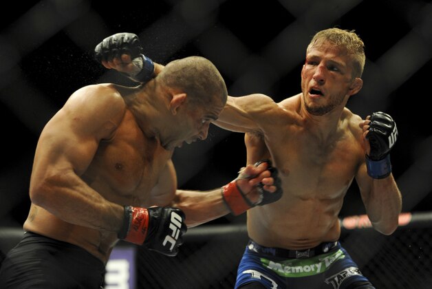 May 24, 2014; Las Vegas, NV, USA;  Renan Barao (red) dodges a punch from TJ Dillashaw (blue) during their UFC 173 bantamweight championship bout at MGM Grand Garden Arena. Dillashaw won the bout by way of TKO. Mandatory Credit: Stephen R. Sylvanie-USA TODAY Sports