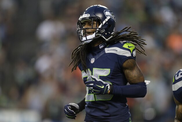 Seattle Seahawks cornerback Richard Sherman runs on the field in the first half of a preseason NFL football game against the Chicago Bears, Friday, Aug. 22, 2014, in Seattle. (AP Photo/John Froschauer)