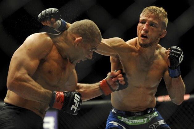 May 24, 2014; Las Vegas, NV, USA;  Renan Barao (red) dodges a punch from TJ Dillashaw (blue) during their UFC 173 bantamweight championship bout at MGM Grand Garden Arena. Dillashaw won the bout by way of TKO. Mandatory Credit: Stephen R. Sylvanie-USA TODAY Sports