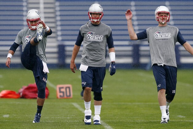 New England Patriots quarterbacks, from left, Jimmy Garoppolo, Tom Brady and Ryan Mallett warm up during an NFL football organized team activity in Foxborough, Mass., Thursday, June 5, 2014. (AP Photo/Michael Dwyer)
