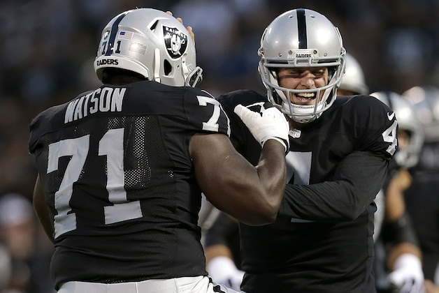 Oakland Raiders quarterback Derek Carr, right, celebrates with Menelik Watson after a Raiders touchdown against the Seattle Seahawks during the first half of an NFL preseason football game in Oakland, Calif., Thursday, Aug. 28, 2014. (AP Photo/Marcio Jose Sanchez)