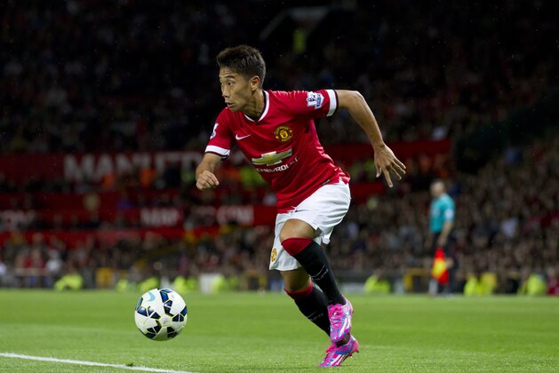 Manchester United's Shinji Kagawa takes the ball downfield, during his team's pre season friendly soccer match against Valencia at Old Trafford Stadium, Manchester, England, Tuesday Aug. 12, 2014. (AP Photo/Jon Super)