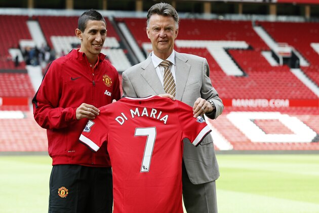Manchester United's new player Angel Di Maria left, and manager Louis van Gaal, pose for photographers holding his new shirt, at Old Trafford Stadium in Manchester, England, Thursday, Aug. 28, 2014. Manchester United have signed winger Angel Di Maria from Real Madrid for a British record transfer fee of £59.7m. The Argentine winger had a medical in Manchester on Tuesday and has signed a five-year deal. (AP Photo/Alastair Grant)