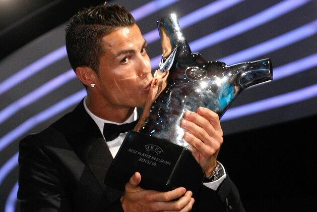 Named the best player of the year, Real Madrid Portuguese forward Cristiano Ronaldo, kisses his trophy during the UEFA Champions League draw, at the Grimaldi Forum, in Monaco, Thursday, Aug. 28, 2014. (AP Photo/Claude Paris)
