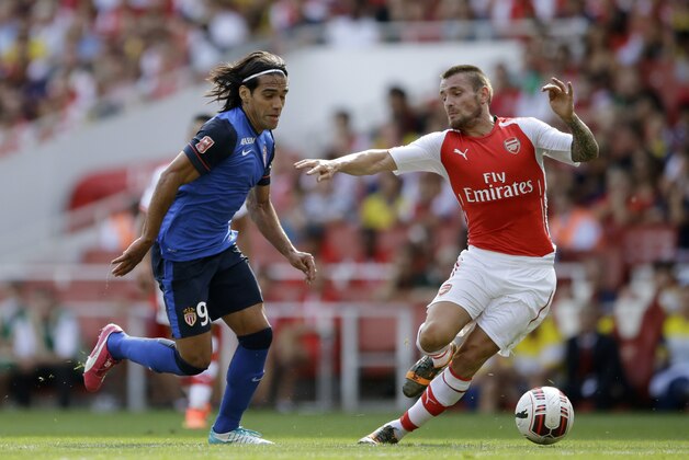 AS Monaco's Radamel Falcao, left, battles for the ball with Aresnal's debutant Mathieu Debuchy during the Emirates Cup soccer match between Arsenal and AS Monaco at Arsenal's Emirates Stadium in London, Sunday, Aug. 3, 2014.  (AP Photo/Matt Dunham)