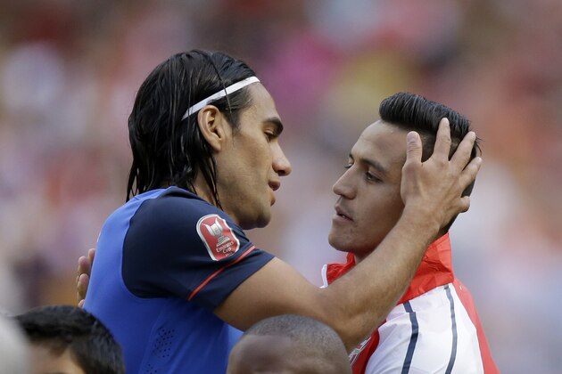 Arsenal's Alexis Sanchez, right, embraces AS Monaco's Radamel Falcao before the Emirates Cup soccer match between Arsenal and AS Monaco at Arsenal's Emirates Stadium in London, Sunday, Aug. 3, 2014.  (AP Photo/Matt Dunham)