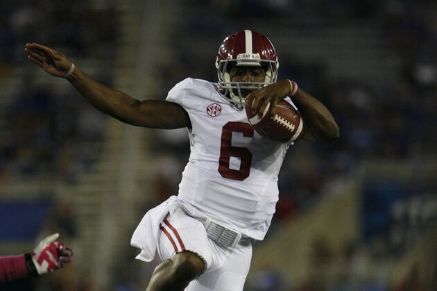 Oct 12, 2013; Lexington, KY, USA; Alabama Crimson Tide quarterback Blake Sims (6) leaps over Kentucky Wildcats cornerback Rodney Cox (21) during the game at Commonwealth Stadium. Alabama defeated Kentucky  48-7. Mandatory Credit: Mark Zerof-USA TODAY Sports