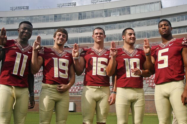 Florida State quarterbacks John Franklin III (11), Troy Cook (19), J. J. Cosentino (16), Sean Maguire (10) and Jameis Winston (5) make a Boy Scout sign as they pose for a photo during their NCAA college football media day on Sunday, Aug. 10, 2014, in Tallahassee, Fla. (AP Photo/Phil Sears)
