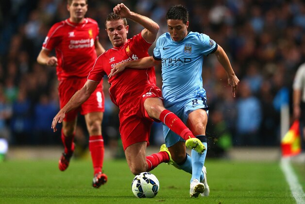 MANCHESTER, ENGLAND - AUGUST 25:  Jordan Henderson of Liverpool challenges Samir Nasri of Manchester City during the Barclays Premier League match between Manchester City and Liverpool at the Etihad Stadium on August 25, 2014 in Manchester, England.  (Photo by Clive Brunskill/Getty Images)