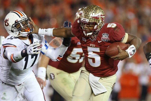 Jan 6, 2014; Pasadena, CA, USA; Florida State Seminoles quarterback Jameis Winston (5) stiff arms Auburn Tigers linebacker Kris Frost (17) during the first half of the 2014 BCS National Championship game at the Rose Bowl.  Mandatory Credit: Matthew Emmons-USA TODAY Sports