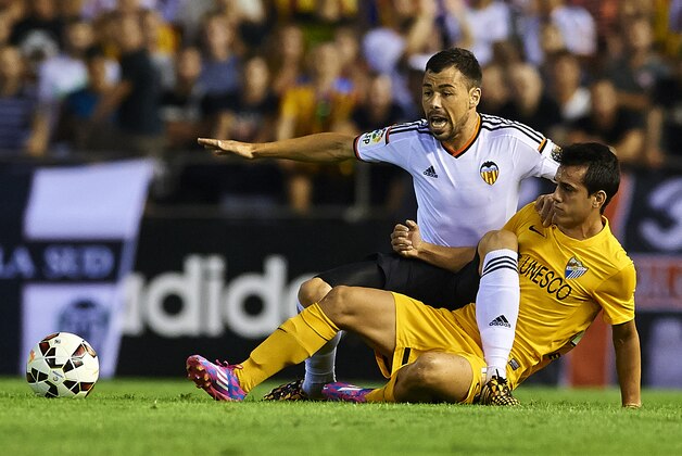 VALENCIA, SPAIN - AUGUST 29:  Javi Fuego (L) of Valencia competes for the ball with Juanmi of Malaga during the La Liga match between Valencia CF and Malaga CF at Estadi de Mestalla on August 29, 2014 in Valencia, Spain.  (Photo by Manuel Queimadelos Alonso/Getty Images)