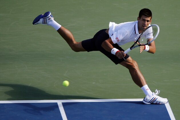 Novak Djokovic, of Serbia, returns a shot to Paul-Henri Mathieu, of France, during the second round of the 2014 U.S. Open tennis tournament, Thursday, Aug. 28, 2014, in New York. (AP Photo/Elise Amendola)