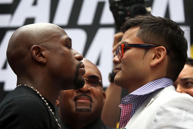 Jul 14, 2014; New York, NY, USA;  Floyd Mayweather Jr. and Marcos Maidana (right) stare at each other during face off to promote their upcoming welterweight rematch during a press conf at Times Square. Mandatory Credit: Noah K. Murray-USA TODAY Sports