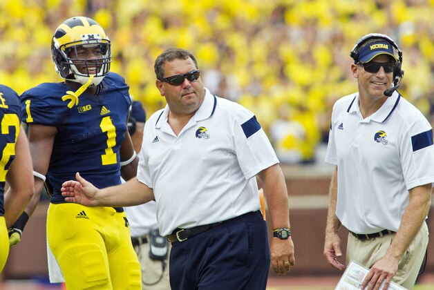 Michigan wide receiver Devin Funchess (1) stands with head coach Brady Hoke, center, and offensive coordinator Doug Nussmeier, right, greeting players coming off the field after a touchdown in the third quarter of an NCAA college football game against Appalachian State in Ann Arbor, Mich., Saturday, Aug. 30, 2014. Michigan won 52-14. (AP Photo/Tony Ding)