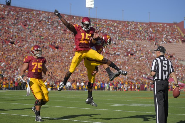 Southern California wide receiver Nelson Agholor, second from left, celebrates with quarterback Cody Kessler as center Max Tuerk, left, looks on after scoring a touchdown during they first half of an NCAA college football game against Fresno State, Saturday, Aug. 30, 2014, in Los Angeles. (AP Photo/Mark J. Terrill)