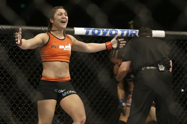 Bethe Correia, left, celebrates after defeating Shayna Baszler, rear, who is tended to by referee John McCarthy after a women's bantamweight mixed martial arts bout at UFC 177 in Sacramento, Calif., Saturday, Aug. 30, 2014. Correia won in the second round. (AP Photo/Jeff Chiu)