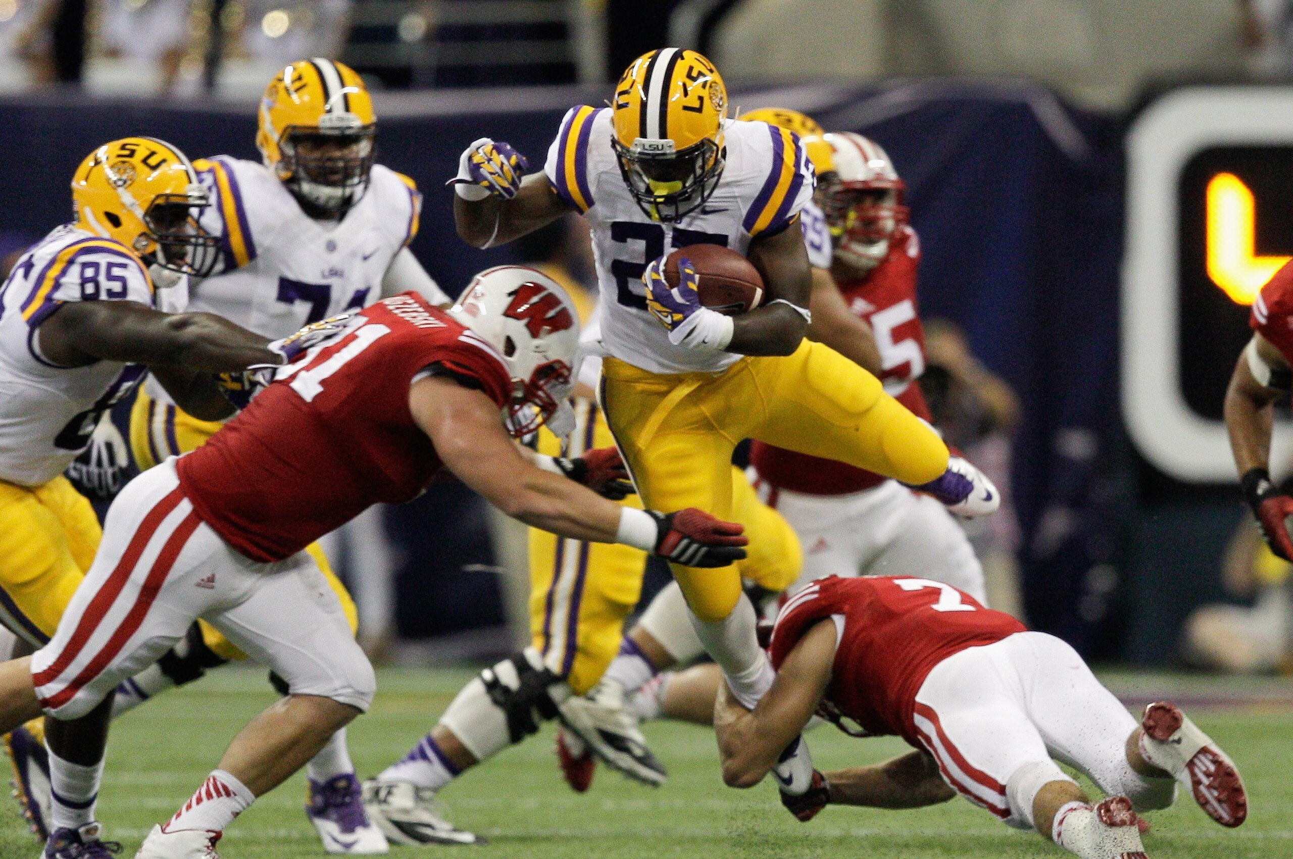 HOUSTON, TX - AUGUST 30:  Kenny Hilliard #27 of the LSU Tigers is tackled by Konrad Zagzebski #91 of the Wisconsin Badgers at NRG Stadium on August 30, 2014 in Houston, Texas. Zagzebeski was injured on the play and to be taken off on a stretcher.  (Photo by Bob Levey/Getty Images)