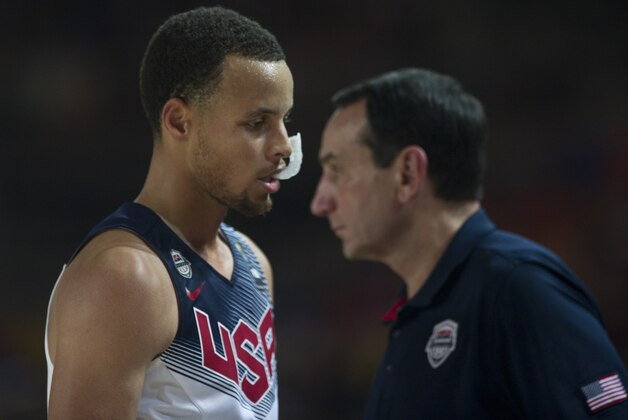 United States's Stephen Curry, leaves the pitch as crosses beside coach Mike Krzyzewski, right, during the Group C Basketball World Cup match against Finland  in Bilbao northern Spain, Saturday, Aug. 30, 2014. The 2014 Basketball World Cup competition will take place in various cities in Spain from Aug. 30 through to Sept. 14. (AP Photo/Alvaro Barrientos)