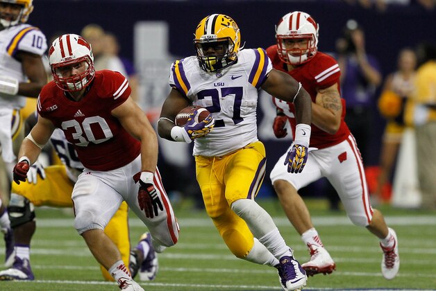 HOUSTON, TX - AUGUST 30:  Kenny Hilliard #27 of the LSU Tigers runs past Derek Landisch #30 of the Wisconsin Badgers in the fourth quarter at NRG Stadium on August 30, 2014 in Houston, Texas.  (Photo by Bob Levey/Getty Images)