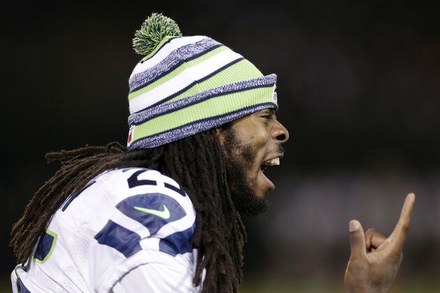 Seattle Seahawks cornerback Richard Sherman yells on the sideline during the second half of an NFL preseason football game against the Oakland Raiders in Oakland, Calif., Thursday, Aug. 28, 2014. (AP Photo/Marcio Jose Sanchez)