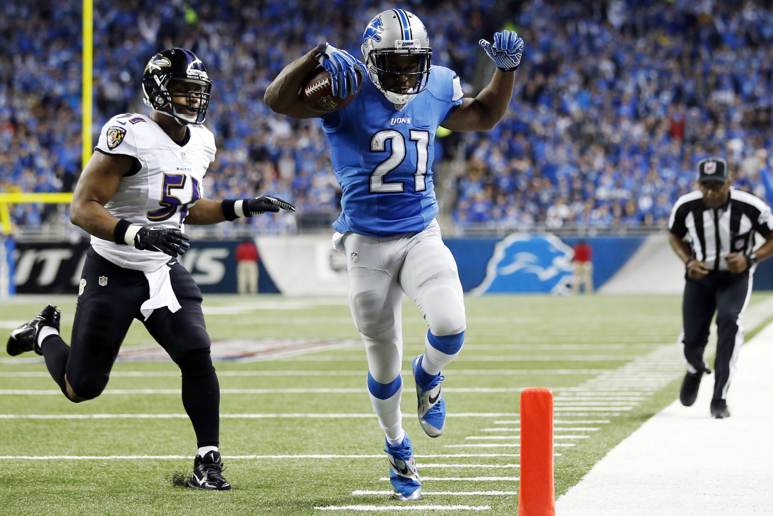 Detroit Lions running back Reggie Bush (21) scores ahead of Baltimore Ravens inside linebacker Daryl Smith (51) for a 14-yard touchdown during the first quarter of an NFL football game in Detroit, Monday, Dec. 16, 2013. (AP Photo/Rick Osentoski)
