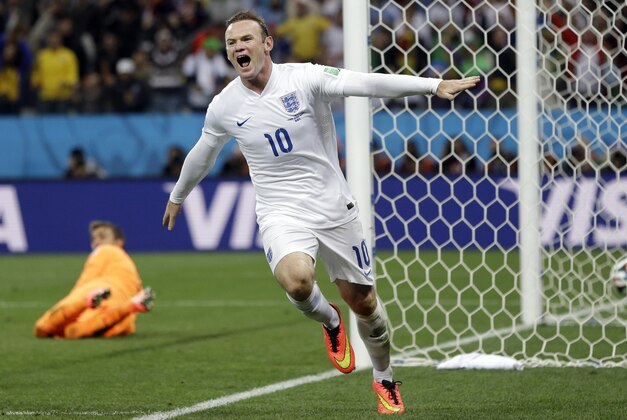 FILE - This is a Thursday, June 19, 2014   file photo of Uruguay's goalkeeper Fernando Muslera looks back as England's Wayne Rooney celebrates after scoring his side's first goal during the group D World Cup soccer match between Uruguay and England at the Itaquerao Stadium in Sao Paulo, Brazil.  Wayne Rooney was named England captain on Thursday, Aug. 28, 2014  taking over the leadership role of an inexperienced team in a rebuilding phase following its worst-ever World Cup. (AP Photo/Kirsty Wigglesworth, File)