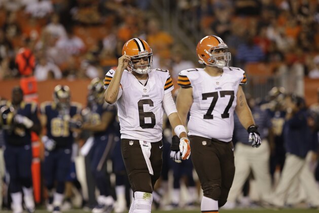 Cleveland Browns quarterback Brian Hoyer (6) walks off the field with guard John Greco (77) after fumbling the ball away to the St. Louis Rams in the third quarter of a preseason NFL football game Saturday, Aug. 23, 2014, in Cleveland. (AP Photo/Tony Dejak)