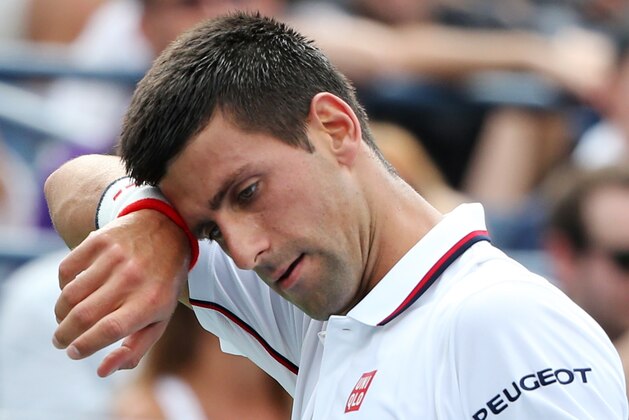 Novak Djokovic, of Serbia, wipes sweat from his face between points against Philipp Kohlschreiber, of Germany, during the fourth round of the 2014 U.S. Open tennis tournament, Monday, Sept. 1, 2014, in New York. (AP Photo/John Minchillo)