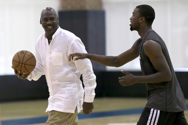 Charlotte Hornets owner Michael Jordan, left, jokes with forward Michael Kidd-Gilchrist, right, during an NBA draft basketball workout in Charlotte, N.C., Tuesday, June 24, 2014. (AP Photo/Chuck Burton)