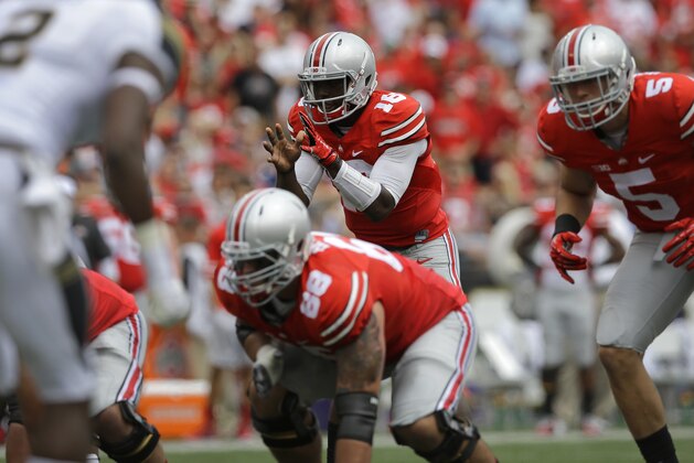 Ohio State quarterback J.T. Barrett, center, prepares to run a play in the first half of an NCAA college football game against Navy in Baltimore, Saturday, Aug. 30, 2014. (AP Photo/Patrick Semansky)