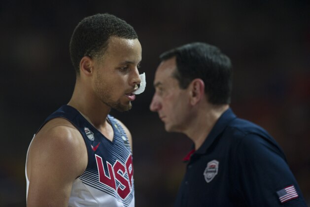 United States's Stephen Curry, leaves the pitch as crosses beside coach Mike Krzyzewski, right, during the Group C Basketball World Cup match against Finland  in Bilbao northern Spain, Saturday, Aug. 30, 2014. The 2014 Basketball World Cup competition will take place in various cities in Spain from Aug. 30 through to Sept. 14. (AP Photo/Alvaro Barrientos)