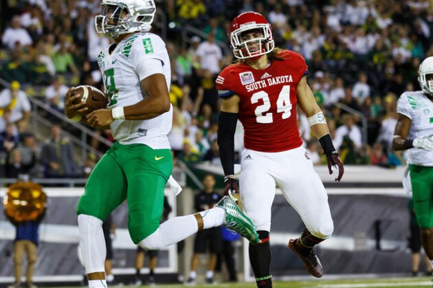 Oregon quarterback Marcus Mariota (8) runs into the end zone for a touchdown during the second quarter of an NCAA college football game against South Dakota in Eugene, Ore., Saturday, Aug. 30, 2014. (AP Photo/Ryan Kang)