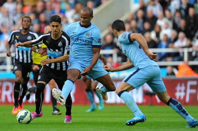 NEWCASTLE UPON TYNE, ENGLAND - AUGUST 17:  Vincent Kompany of Man City (c) challenges Ayoze Perez of Newcastle during the Barclays Premier League match between Newcastle United and Manchester City at St James' Park on August 17, 2014 in Newcastle upon Tyne, England.  (Photo by Stu Forster/Getty Images)
