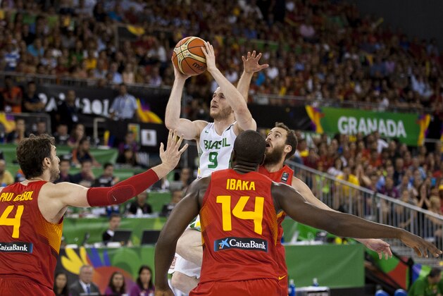 Brazil's Marcelinho Huertas, top, shoots over Spain's Pau Gasol, left, Serge Ibaka, no. 14, and Sergio Rodriguez, right, during the Group A Basketball World Cup match between Brazil and Spain in Granada, Spain, Monday, Sept. 1, 2014. The 2014 Basketball World Cup competition will take place in various cities in Spain from Aug. 30 through to Sept. 14. (AP Photo/Daniel Tejedor)