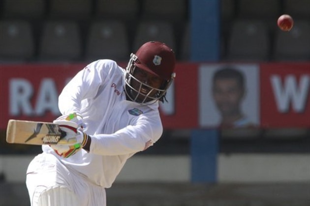 West Indies opening batsman Chris Gayle, left, plays a shot during the second innings on the last day of the second cricket Test match against New Zealand in Port of Spain, Trinidad, Friday, June 20, 2014. West Indies won the second Test match by 10 wickets tying the series 1-1. (AP Photo/Arnulfo Franco)
