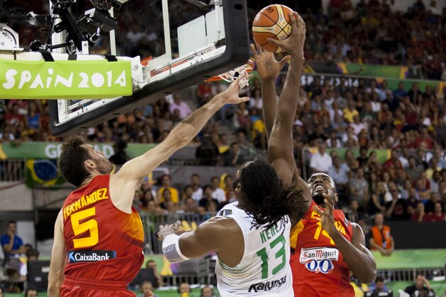 Brazil's Nene Hilario, center, shoots over Spain's Rudy Fernandez, left, and Serge Ibaka during the Group A Basketball World Cup match between Brazil and Spain in Granada, Spain, Monday, Sept. 1, 2014. The 2014 Basketball World Cup competition will take place in various cities in Spain from Aug. 30 through to Sept. 14. (AP Photo/Daniel Tejedor)